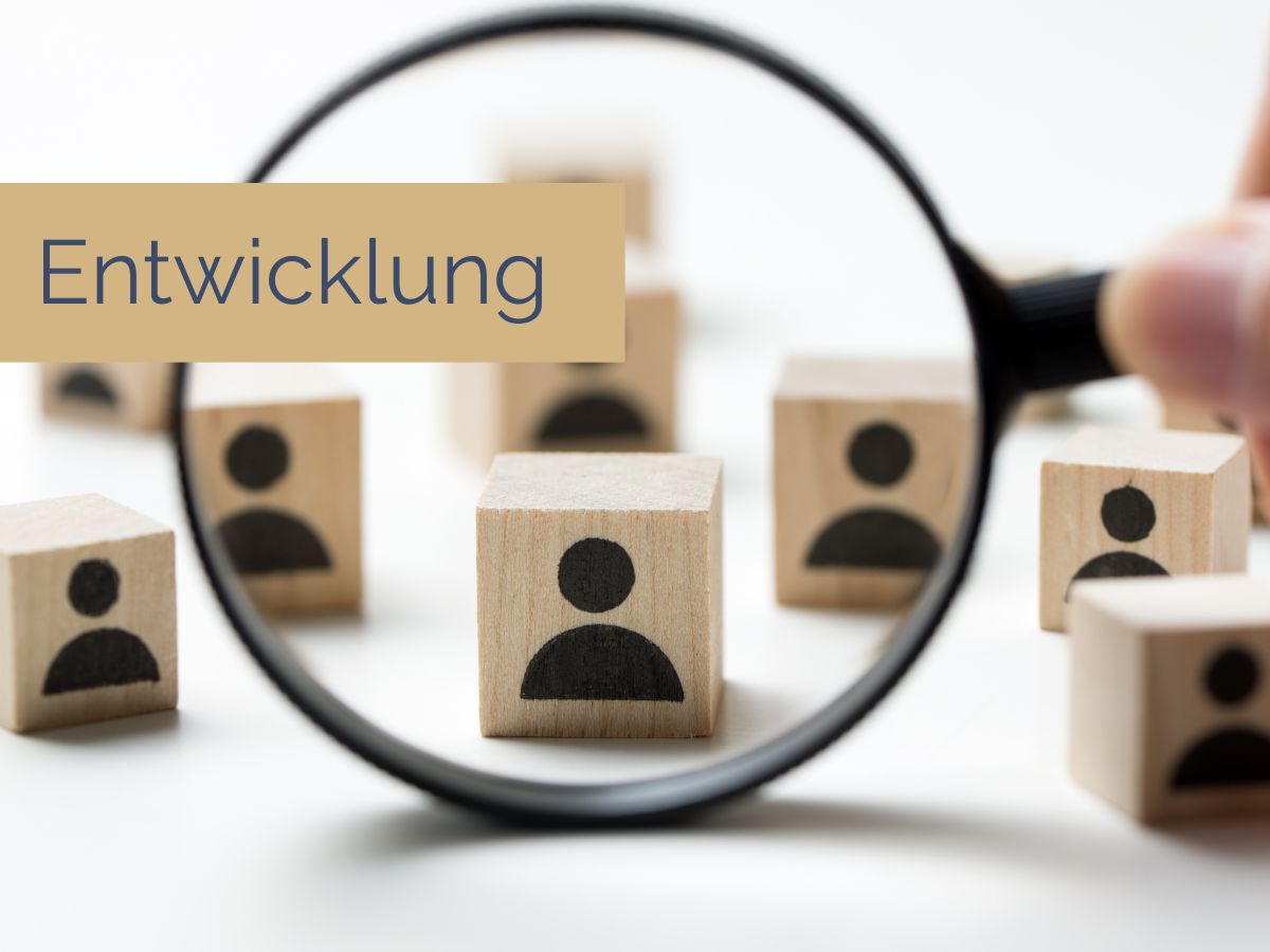 Eine Person im Anzug sitzt an einem Schreibtisch, den Kopf in den Händen, umgeben von zerknüllten Papieren. Unten ist der Text „Stress bewältigen“ zu sehen. Die Umgebung ist hell erleuchtet, im Hintergrund ist ein großes Fenster.